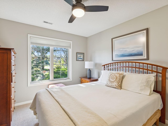 carpeted bedroom with a textured ceiling and ceiling fan