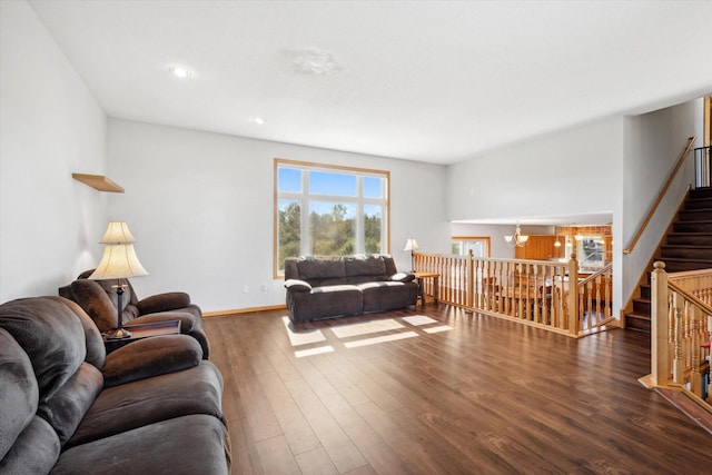 living room with dark hardwood / wood-style floors and an inviting chandelier