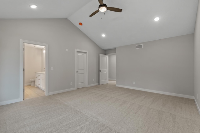 unfurnished bedroom featuring light carpet, ensuite bath, ceiling fan, and high vaulted ceiling