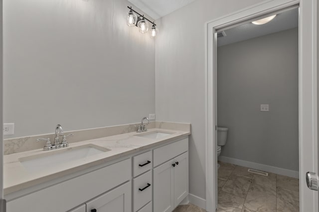 bathroom featuring a textured ceiling, vanity, and toilet