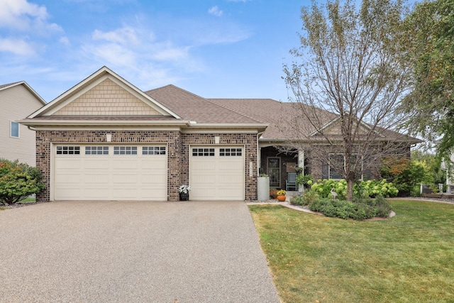 view of front facade with aphalt driveway, brick siding, a garage, and a front yard