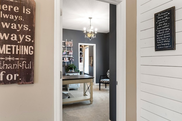 hallway with baseboards, carpet floors, and a chandelier