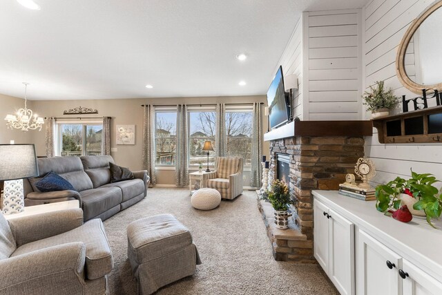 living room featuring light colored carpet, wood walls, a stone fireplace, recessed lighting, and a notable chandelier