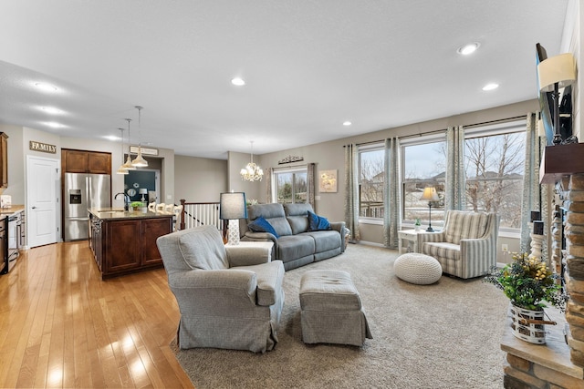 living area featuring an inviting chandelier, recessed lighting, and light wood-style floors