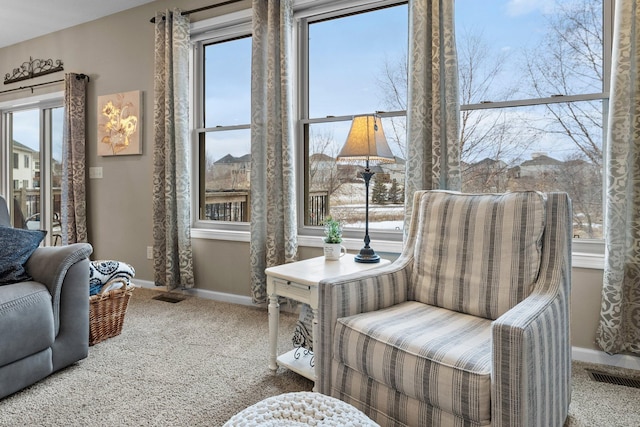 sitting room with carpet, visible vents, and baseboards