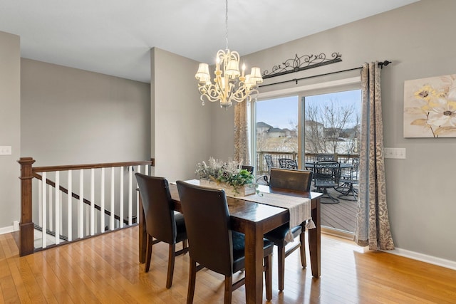 dining area with baseboards, a chandelier, and hardwood / wood-style flooring