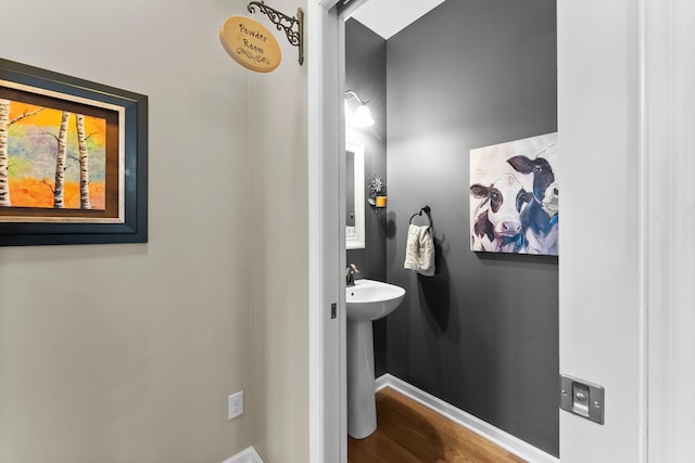 bathroom featuring a sink, baseboards, and wood finished floors