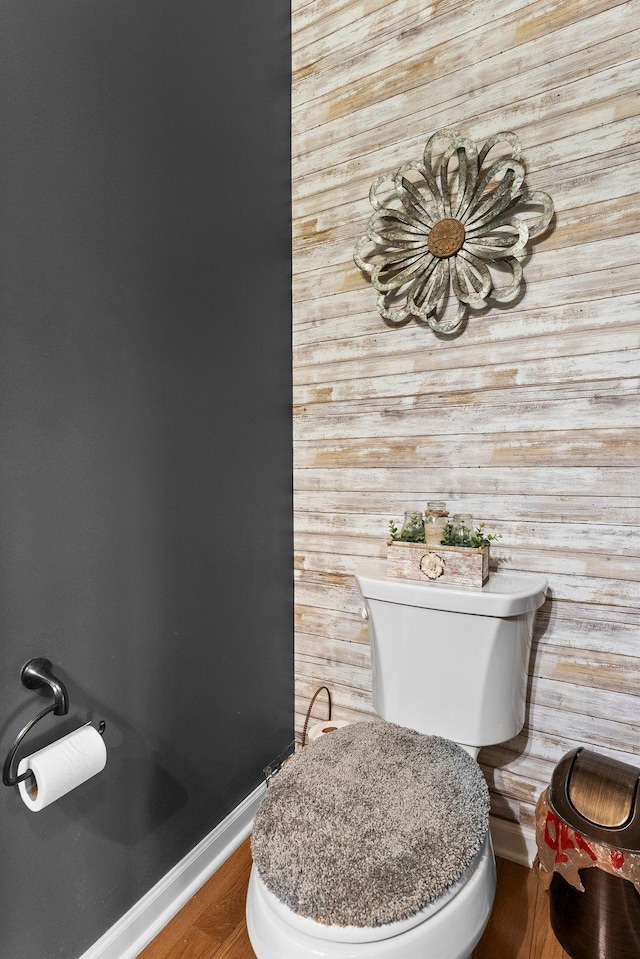 bathroom featuring toilet, wood finished floors, and baseboards