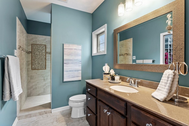 bathroom featuring baseboards, toilet, vanity, and a walk in shower