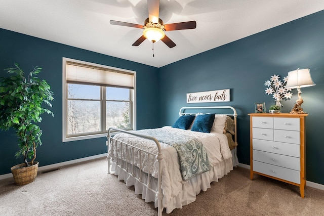 carpeted bedroom featuring baseboards and a ceiling fan