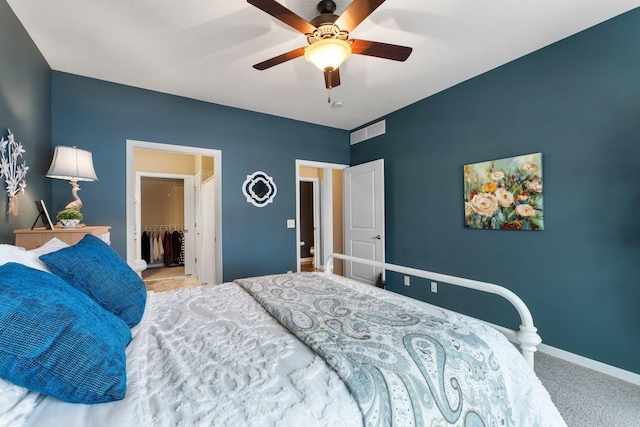 bedroom with visible vents, carpet floors, baseboards, ceiling fan, and a spacious closet