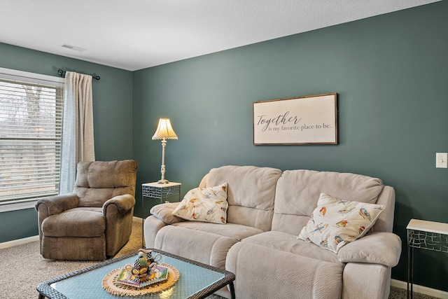 living room with carpet flooring, visible vents, and baseboards