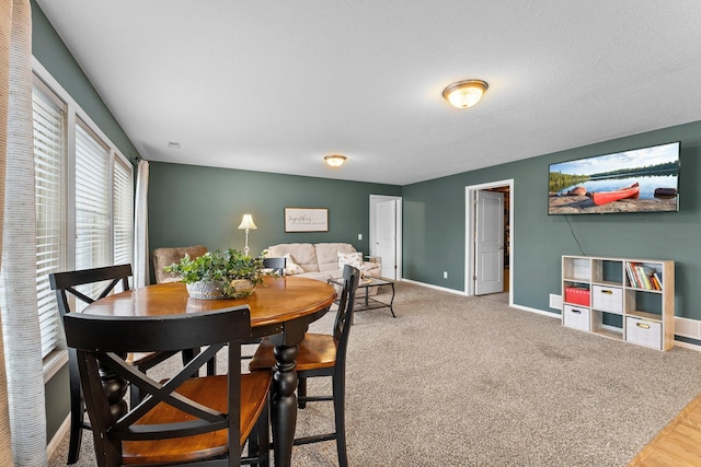 carpeted dining space featuring baseboards