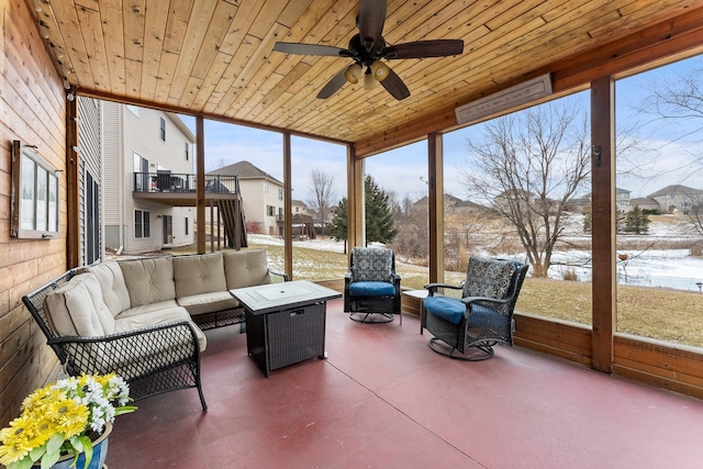 sunroom / solarium with wood ceiling and a ceiling fan