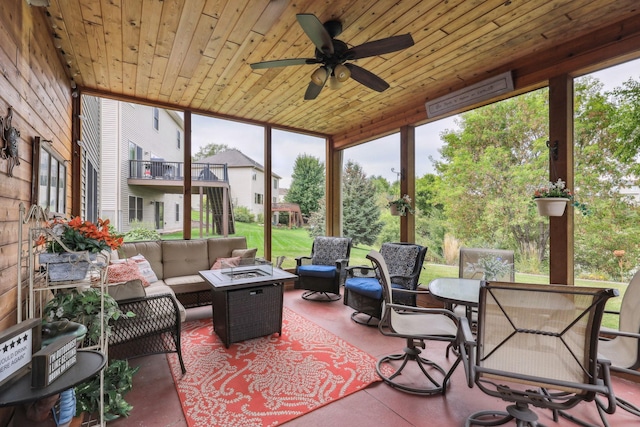 sunroom / solarium featuring plenty of natural light, wood ceiling, and ceiling fan