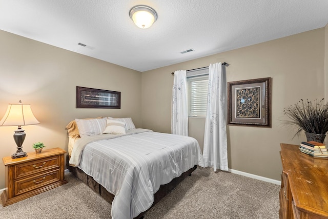 carpeted bedroom featuring baseboards, visible vents, and a textured ceiling