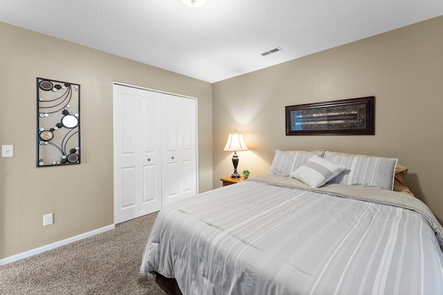 bedroom featuring carpet, visible vents, baseboards, a closet, and a textured ceiling