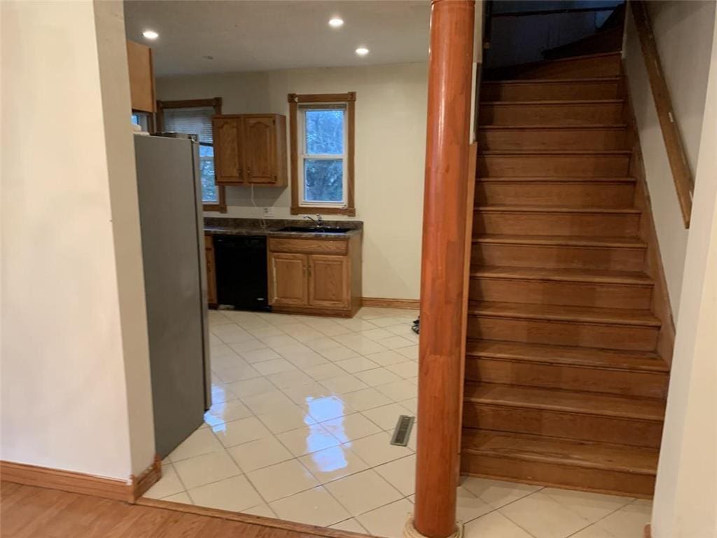 stairs with sink and tile patterned floors