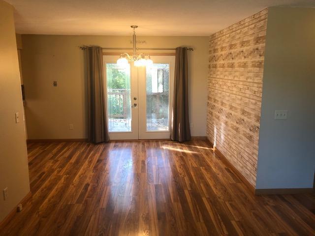 interior space with french doors, a notable chandelier, and dark hardwood / wood-style flooring