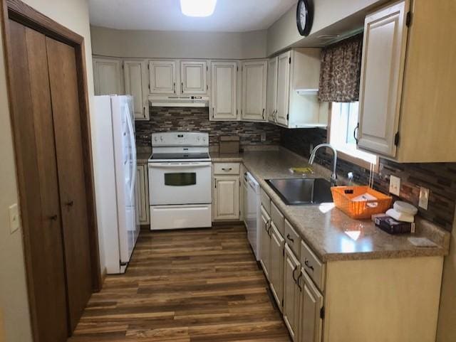 kitchen featuring decorative backsplash, white appliances, dark wood-type flooring, and sink