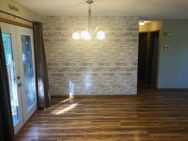 unfurnished dining area with a chandelier and dark wood-type flooring