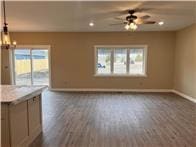 unfurnished living room with recessed lighting, baseboards, a ceiling fan, and dark wood-style floors