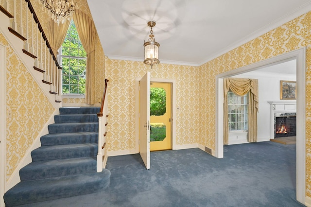 interior space featuring a notable chandelier, ornamental molding, carpet flooring, and a fireplace