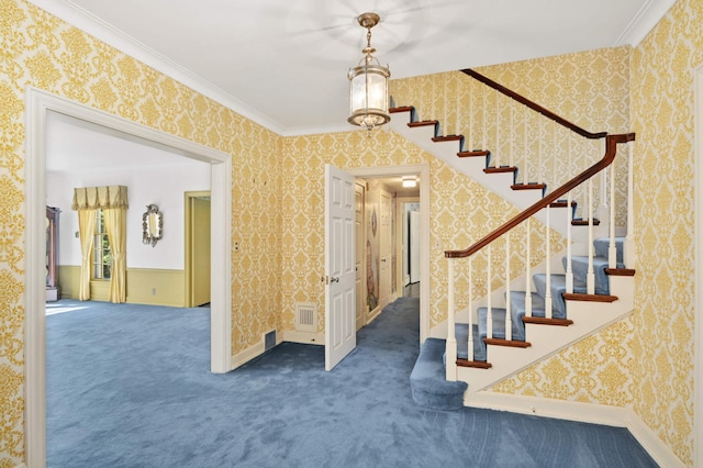 stairs featuring ornamental molding, carpet floors, and an inviting chandelier