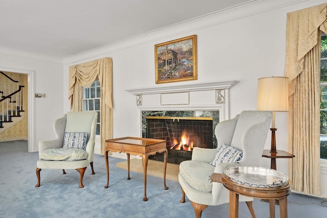 living area featuring crown molding, a high end fireplace, and carpet floors