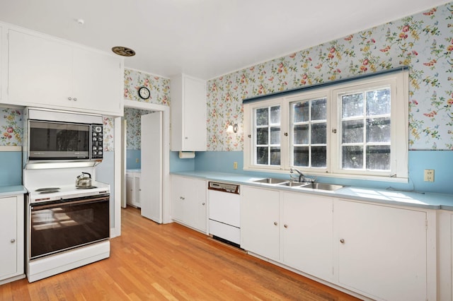 kitchen with white appliances, light hardwood / wood-style flooring, sink, and white cabinets