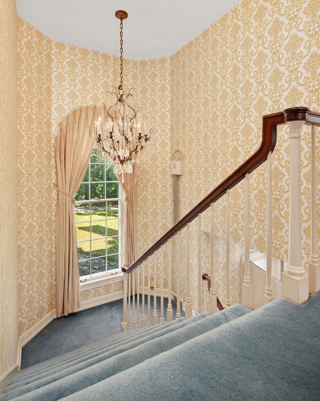 stairs featuring a chandelier and carpet