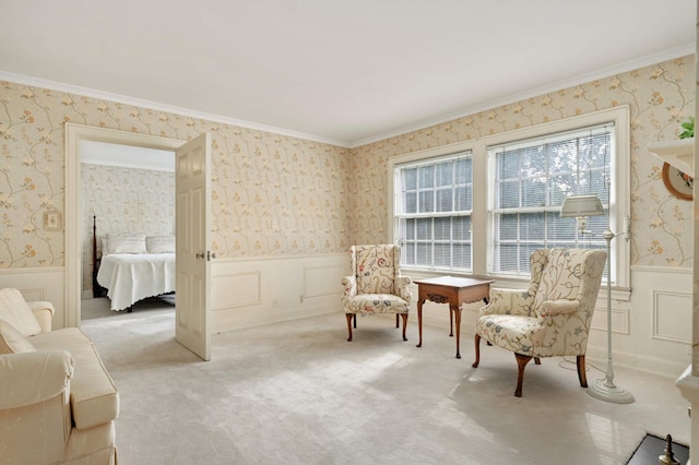 sitting room with ornamental molding and light colored carpet