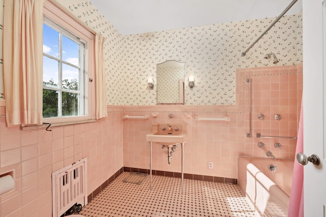 bathroom with shower / tub combination, sink, tile walls, and tile patterned flooring