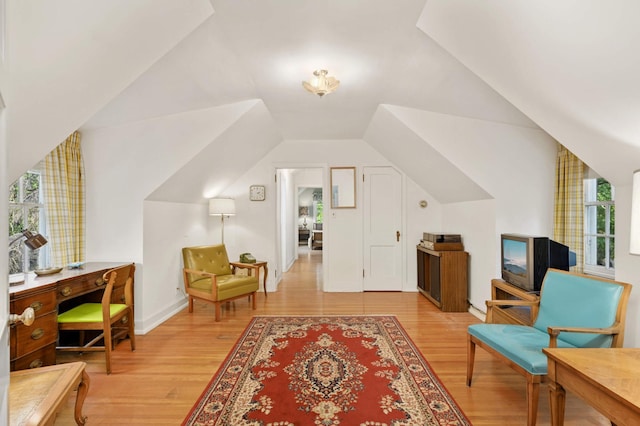 living area with light hardwood / wood-style floors and vaulted ceiling