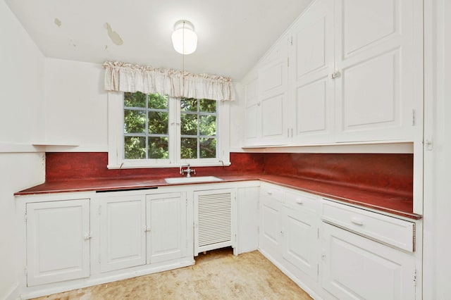 kitchen featuring white cabinetry and sink