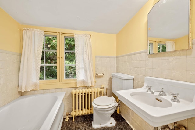 bathroom featuring a tub to relax in, tile walls, radiator heating unit, and toilet