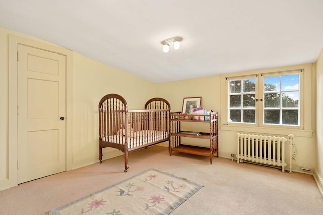 bedroom featuring light carpet and radiator heating unit