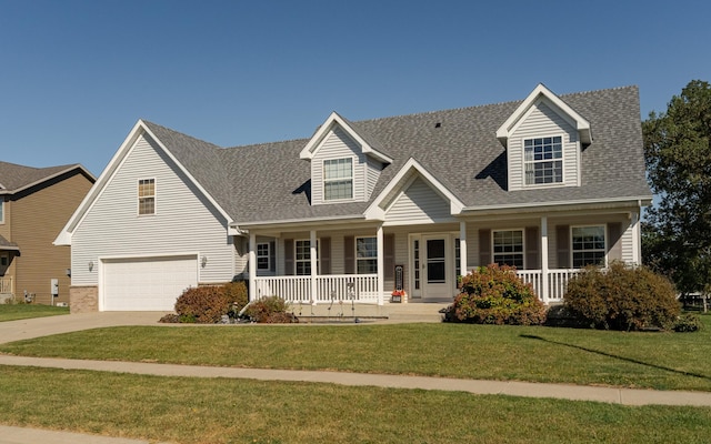 new england style home with a garage, a front yard, and covered porch