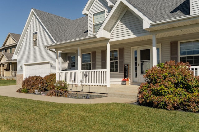 view of front of house with a porch, a garage, and a front yard