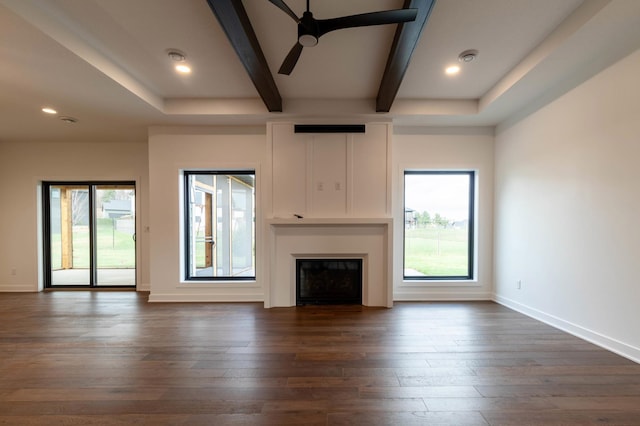 unfurnished living room with dark wood-type flooring, ceiling fan, and beam ceiling