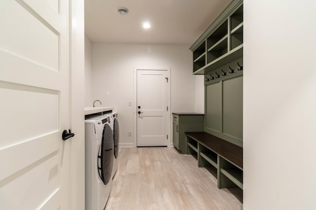 washroom with light hardwood / wood-style flooring and independent washer and dryer