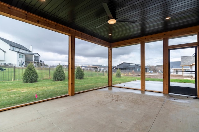 unfurnished sunroom featuring ceiling fan