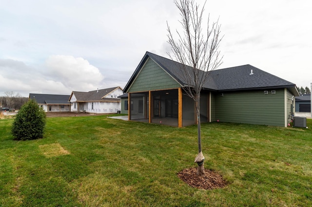 back of house with a sunroom, central AC, a yard, and a patio area