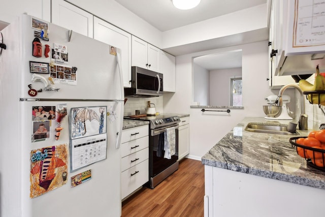 kitchen featuring white cabinets, stainless steel appliances, sink, and light hardwood / wood-style flooring