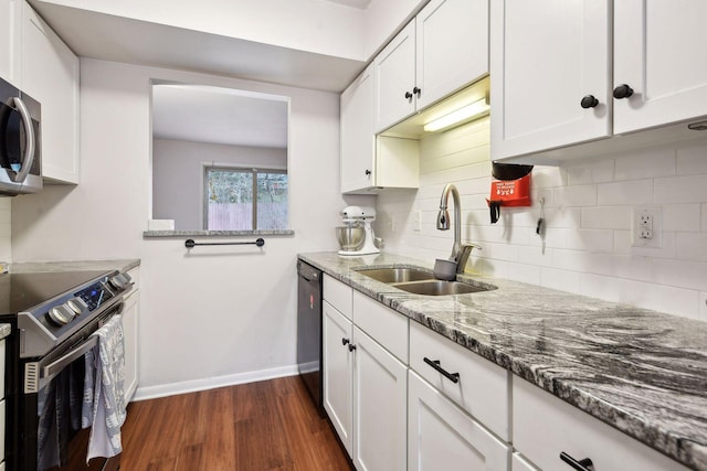 kitchen with white cabinetry, dark wood-type flooring, stone countertops, stainless steel appliances, and sink