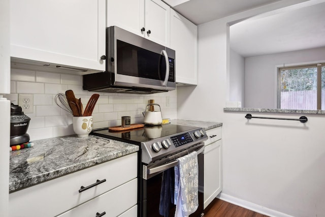 kitchen featuring dark hardwood / wood-style floors, white cabinets, stone counters, decorative backsplash, and stainless steel appliances