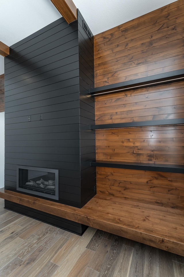 details featuring hardwood / wood-style floors, beamed ceiling, and wood walls