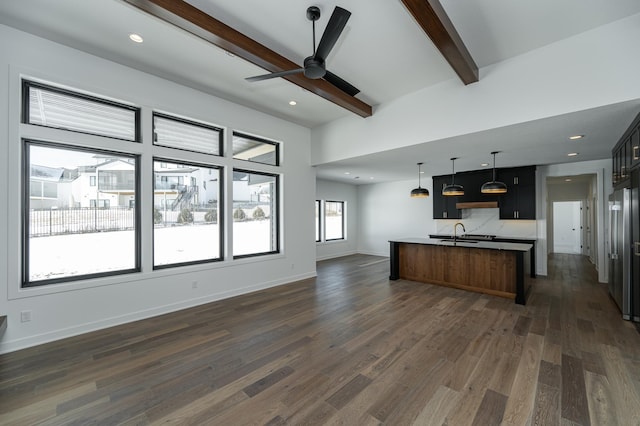 kitchen with sink, ceiling fan, a kitchen island with sink, dark hardwood / wood-style flooring, and beamed ceiling