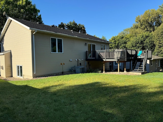 back of property with a lawn, central AC, and a deck