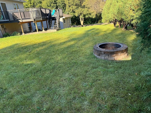 view of yard with a wooden deck and a fire pit